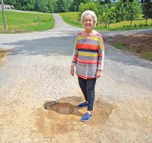 Lynn Town Clerk Marcia Manasco shows a large pothole on 3rd Street that will be resurfaced, thanks to the Rebuild Alabama grant the town has received.